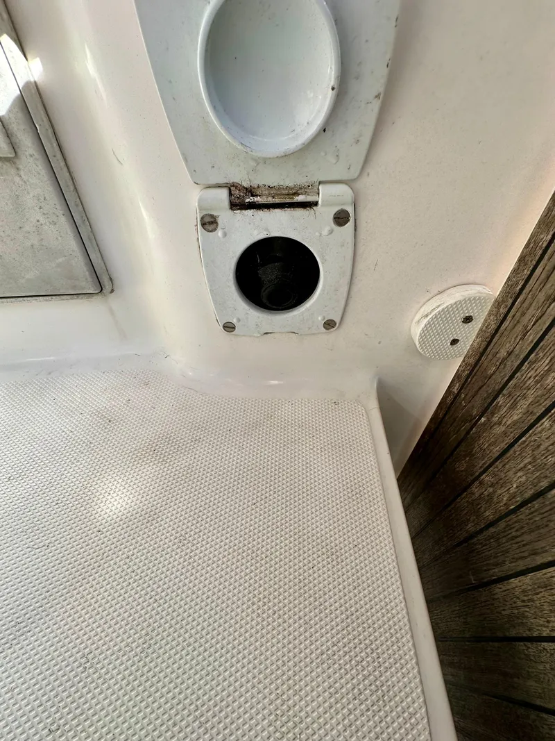 Slide: The Image of Deck detail of a 2014 Hunter 33 sailboat, featuring a circular hatch and textured flooring. - 18