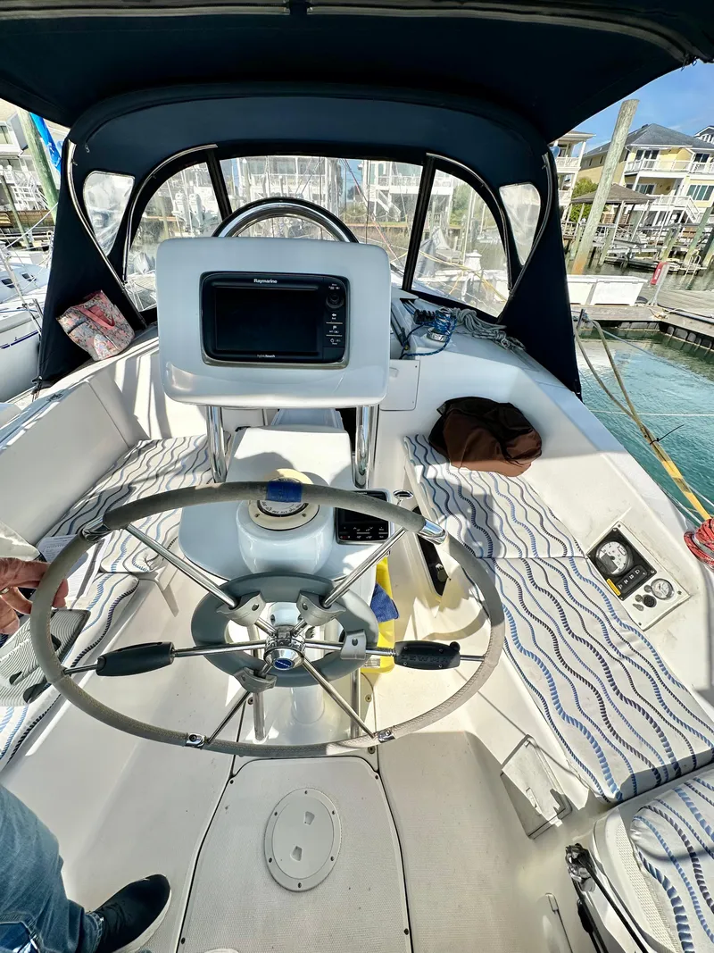 Slide: The Image of 2014 Hunter 33 sailboat cockpit with steering wheel and navigation equipment. - 19