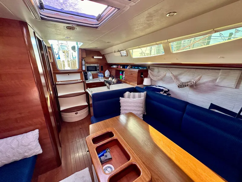 Slide: The Image of Interior of a 2014 Hunter 33 sailboat with blue seating and wooden finishes. - 21