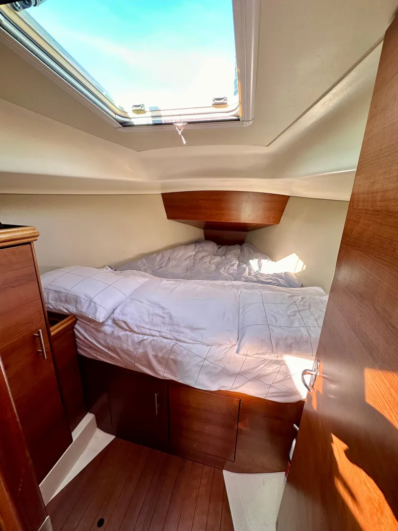 Slide: The Image of 2014 Hunter 33 yacht interior cabin with skylight and wooden furnishings. - 22