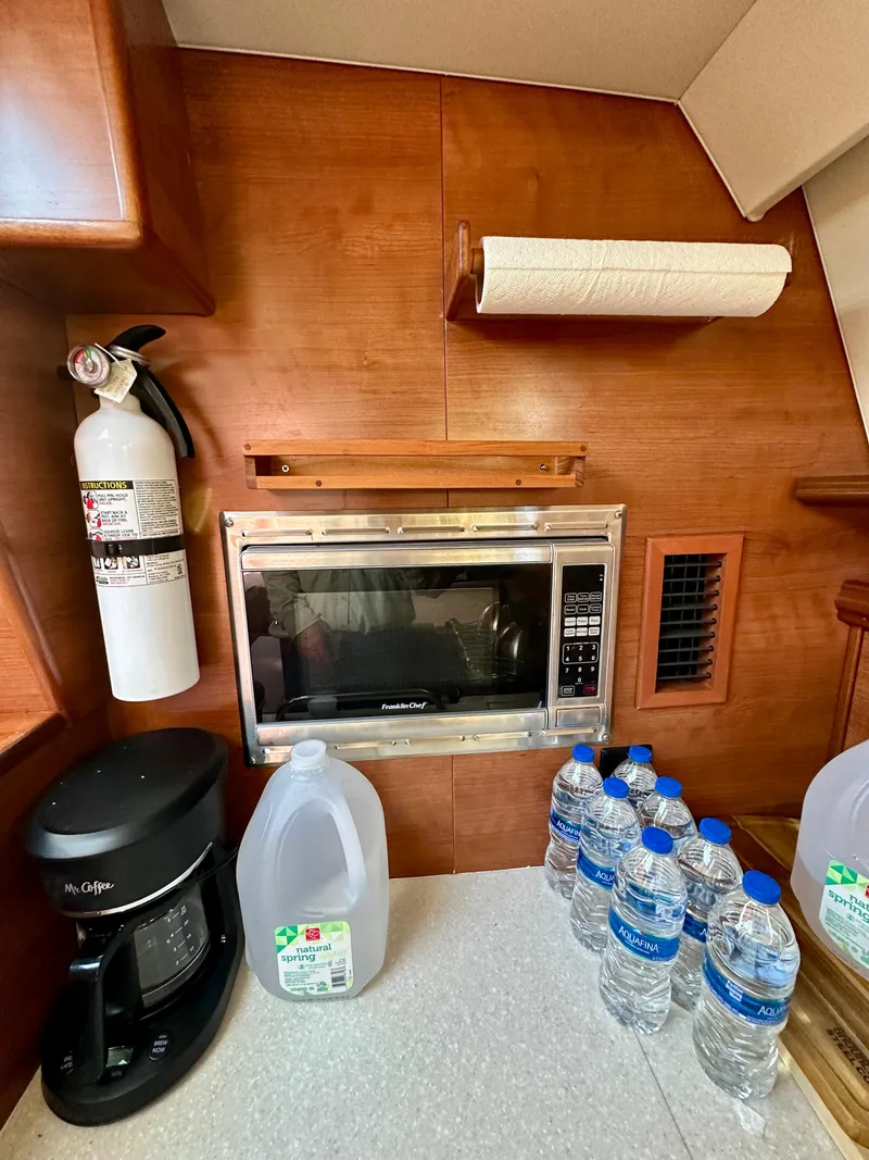 Slide: The Image of Hunter 33 yacht kitchen with microwave, coffee maker, and water bottles, 2014 model. - 24