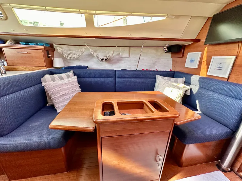 Slide: The Image of Cozy interior of 2014 Hunter 33 sailboat with blue seating and wooden table. - 26