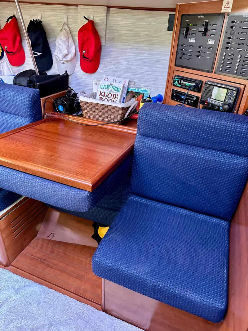 Slide: The Image of Interior of 2014 Hunter 33 sailboat with blue seating and wooden table. - 27