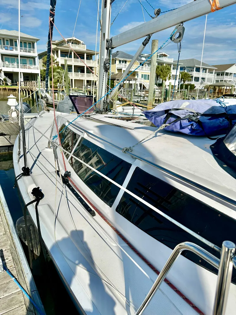 Slide: The Image of Sailboat Hunter 33, 2014 model, docked near waterfront homes. - 3