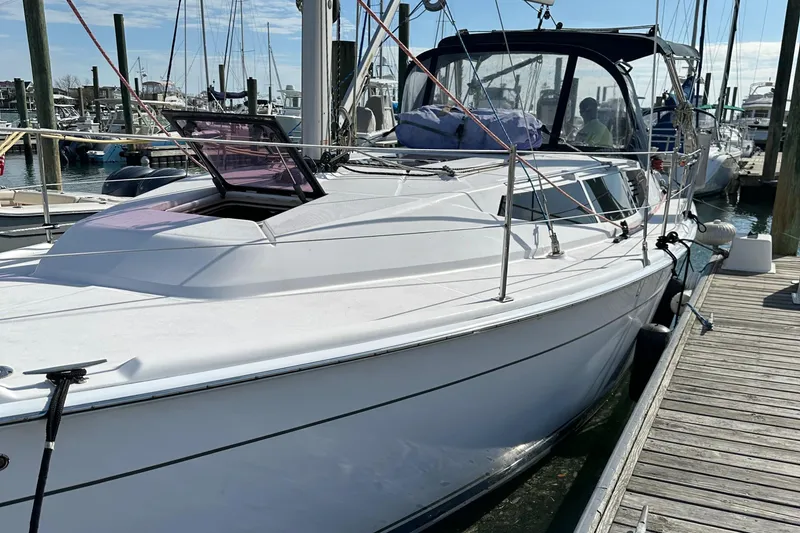 Slide: The Image of 2014 Hunter 33 sailboat docked at marina, featuring sleek white design and spacious deck. - 9