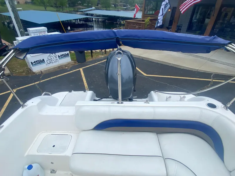 Slide: The Image of 2012 Hurricane SunDeck Sport 201 OB boat with blue canopy and white seating. - 10