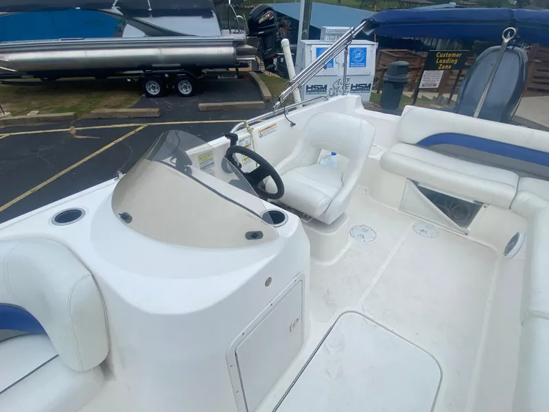 Slide: The Image of 2012 Hurricane SunDeck Sport 201 OB boat interior with white seating and steering console. - 14