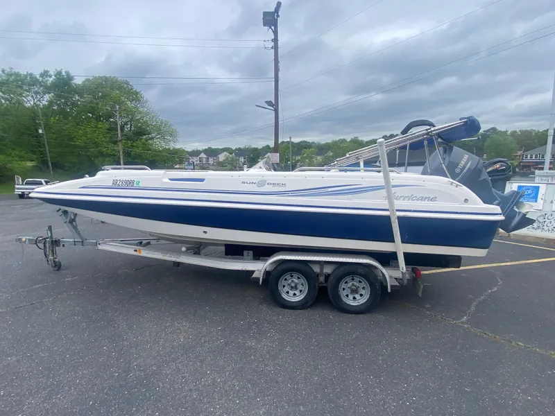 Slide: The Image of 2012 Hurricane SunDeck Sport 201 OB boat on a trailer in a parking lot. - 2