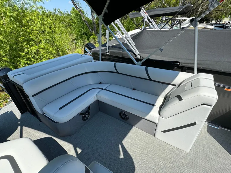 Slide: The Image of 2024 Crest Classic LX 220 pontoon boat with spacious seating area. - 12