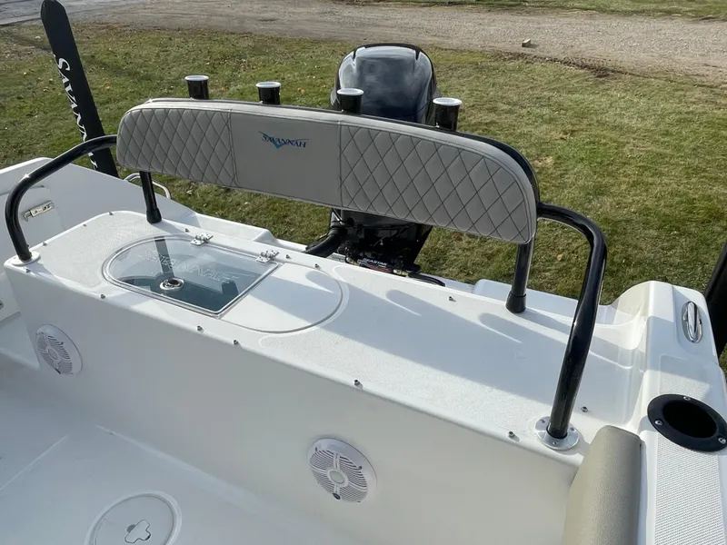 Slide: The Image of 2024 Savannah 2200 Offshore boat interior with cushioned seating and motor. - 7