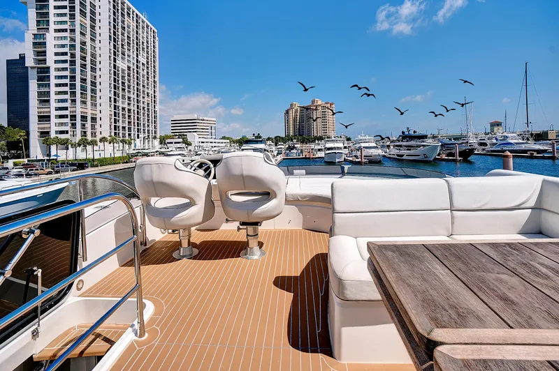 Slide: The Image of 2017 Sunseeker 68 Sport Yacht deck with seating, table, and marina view. - 20
