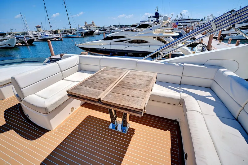 Slide: The Image of Sunseeker 68 Sport Yacht 2017 with spacious deck seating and wooden table at marina. - 23