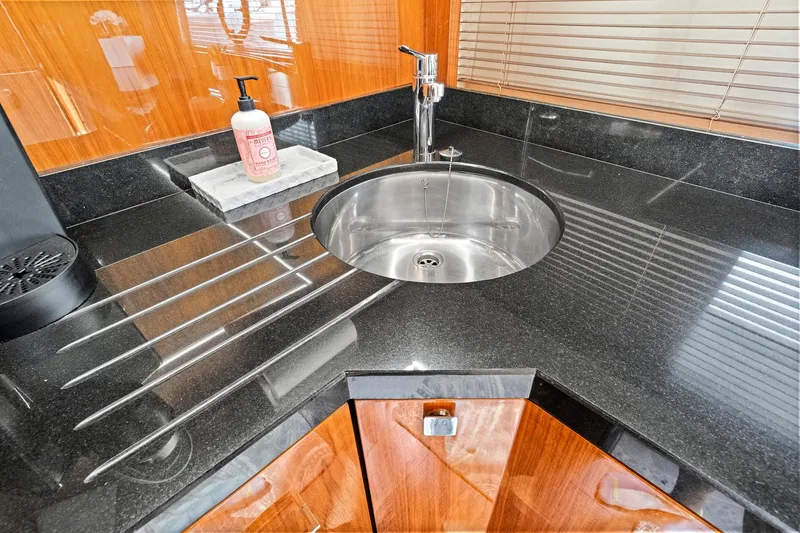 Slide: The Image of Modern kitchen sink in 2017 Sunseeker 68 Sport Yacht with sleek black countertop. - 46