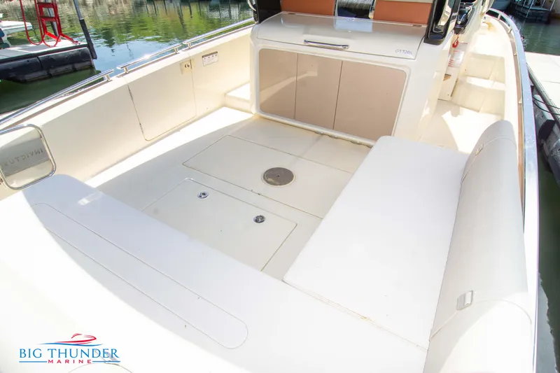 Slide: The Image of 2024 Invictus GT320S boat interior with spacious seating and storage, docked at Big Thunder Marine. - 12