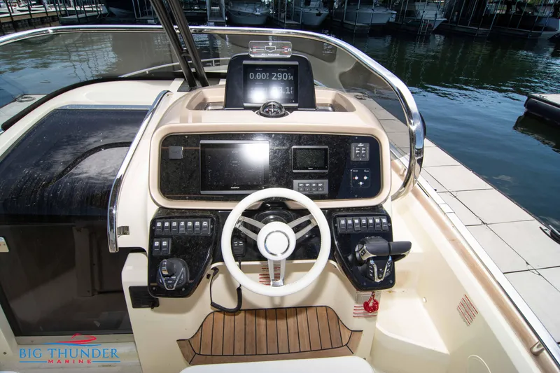 Slide: The Image of 2024 Invictus GT320S boat dashboard with steering wheel and control panel at marina. - 23
