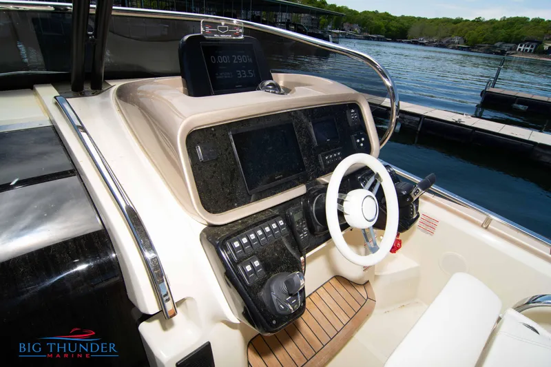 Slide: The Image of 2024 Invictus GT320S boat dashboard with steering wheel and control panel at marina. - 25