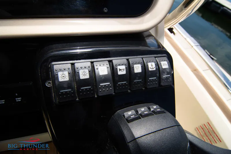 Slide: The Image of Control panel of 2024 Invictus GT320S boat with various switches. - 32