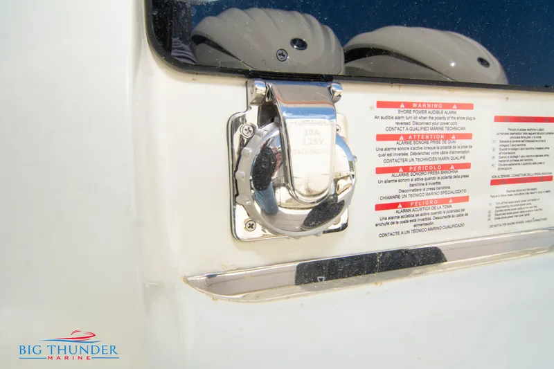 Slide: The Image of Close-up of 2024 Invictus GT320S boat power outlet and warning labels. - 9