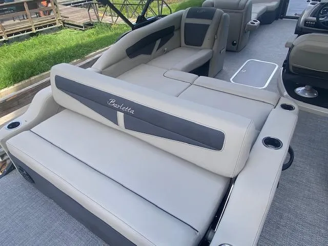 Slide: The Image of 2023 Barletta Cabrio 24 U pontoon boat interior with luxurious seating and cup holders. - 11