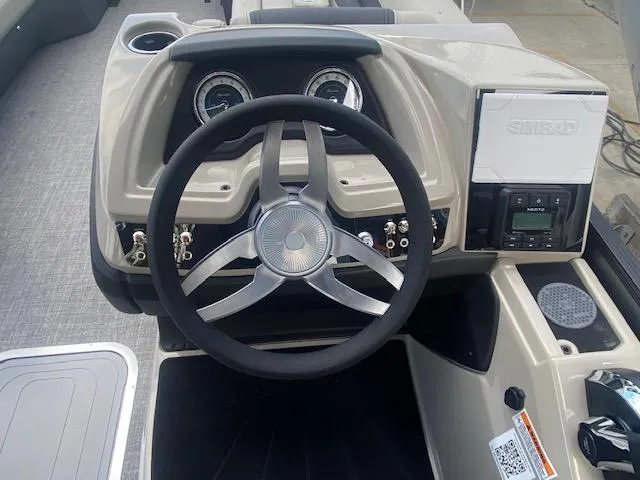 Slide: The Image of 2023 Barletta Cabrio 24 U boat dashboard with steering wheel and control panel. - 17
