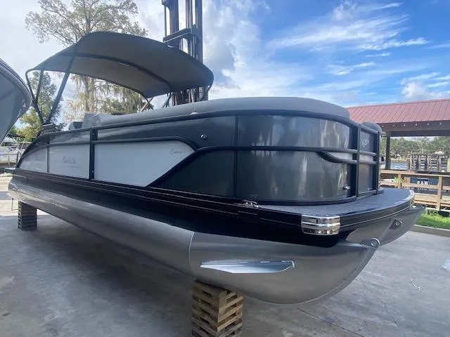 Slide: The Image of 2023 Barletta Cabrio 24 U pontoon boat with canopy, docked on a sunny day. - 7