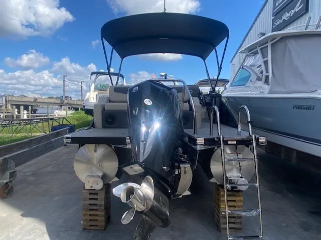 Slide: The Image of 2023 Barletta Cabrio 24 U pontoon boat with outboard motor, docked under blue sky. - 9