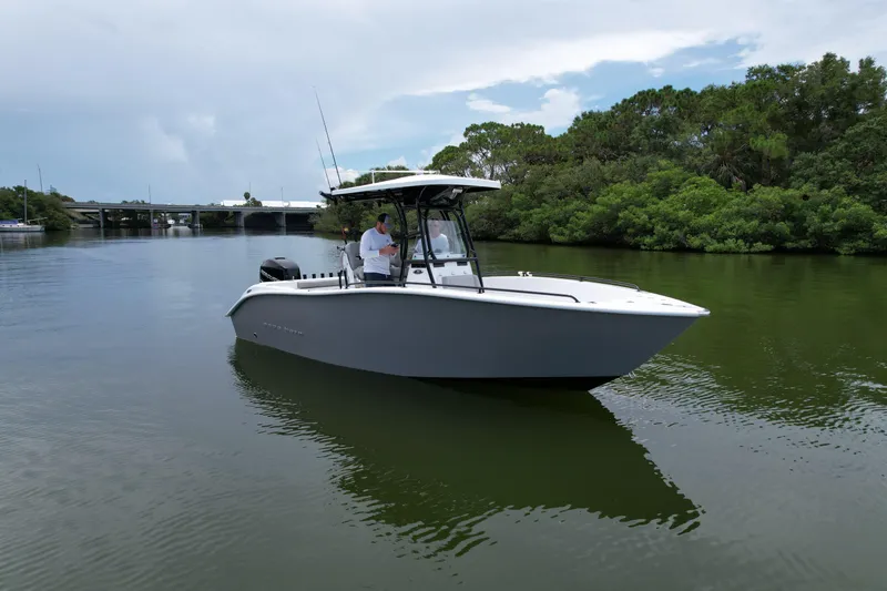 Slide: The Image of 2019 Cape Horn 22 OS boat on calm water near a bridge and trees. - 1