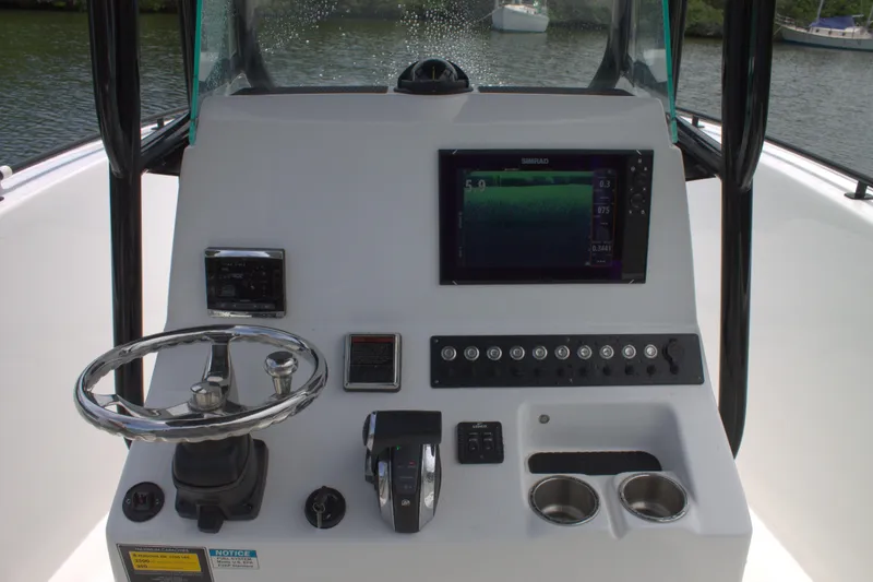 Slide: The Image of 2019 Cape Horn 22 OS boat console with steering wheel, controls, and navigation screen. - 25