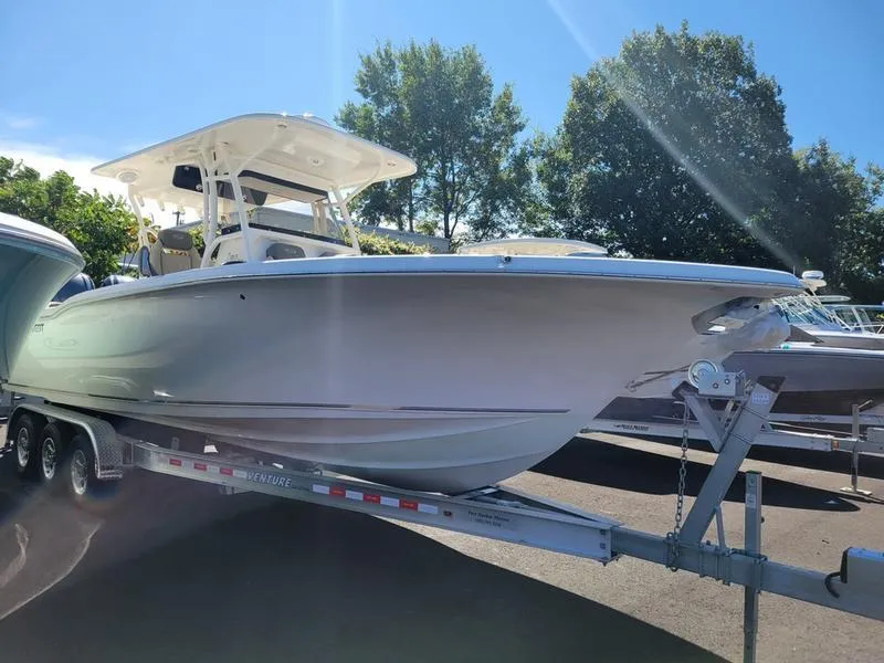 Slide: The Image of 2025 Key West 291 FS boat on trailer, sunny day, trees in background. - 5