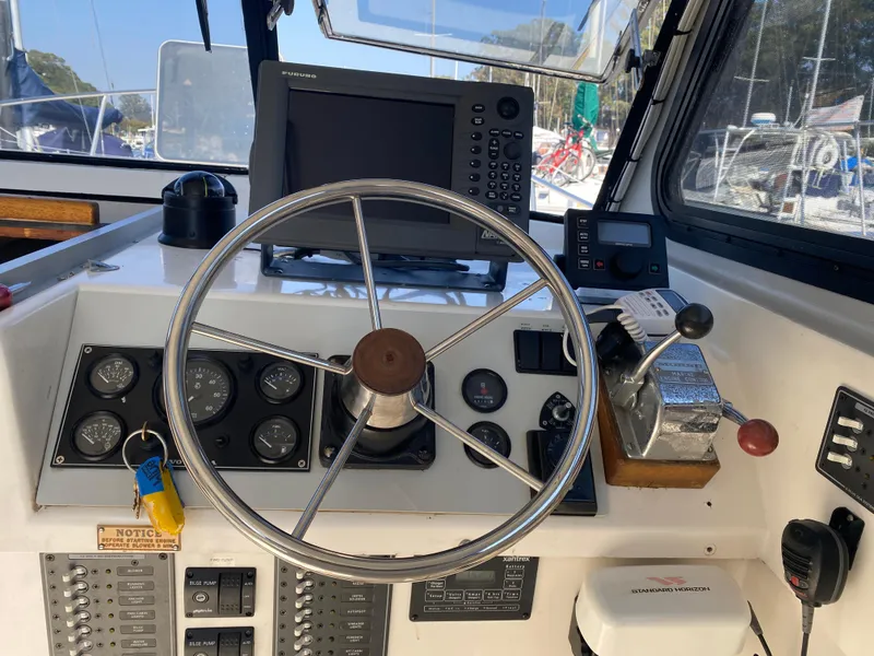 Slide: The Image of 1986 Luhrs Alura helm with steering wheel, gauges, and navigation equipment. - 12
