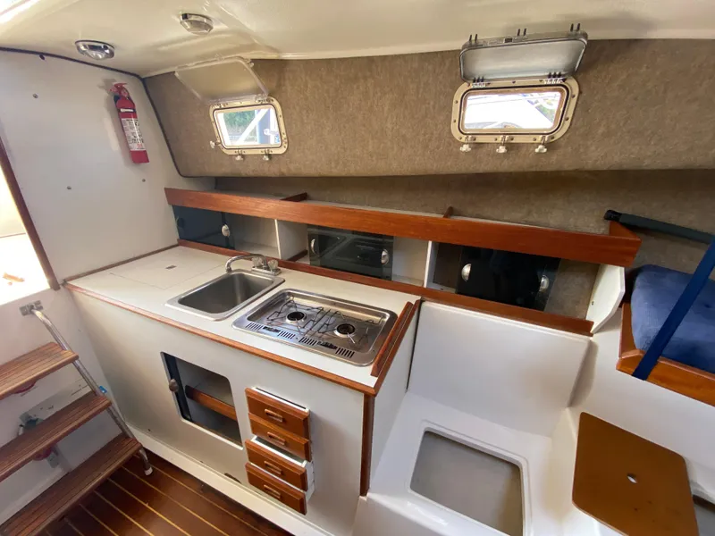 Slide: The Image of 1986 Luhrs Alura boat interior with kitchenette, sink, stove, and wooden accents. - 15