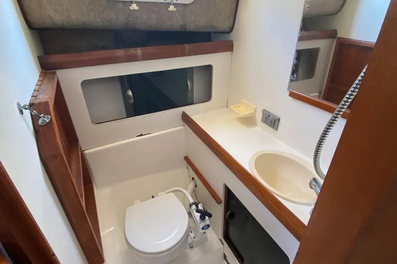 Slide: The Image of 1986 Luhrs Alura boat bathroom with toilet, sink, and showerhead. - 20