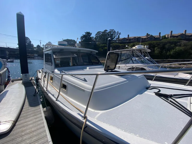 Slide: The Image of 1986 Luhrs Alura boat docked at a marina under clear blue skies. - 3