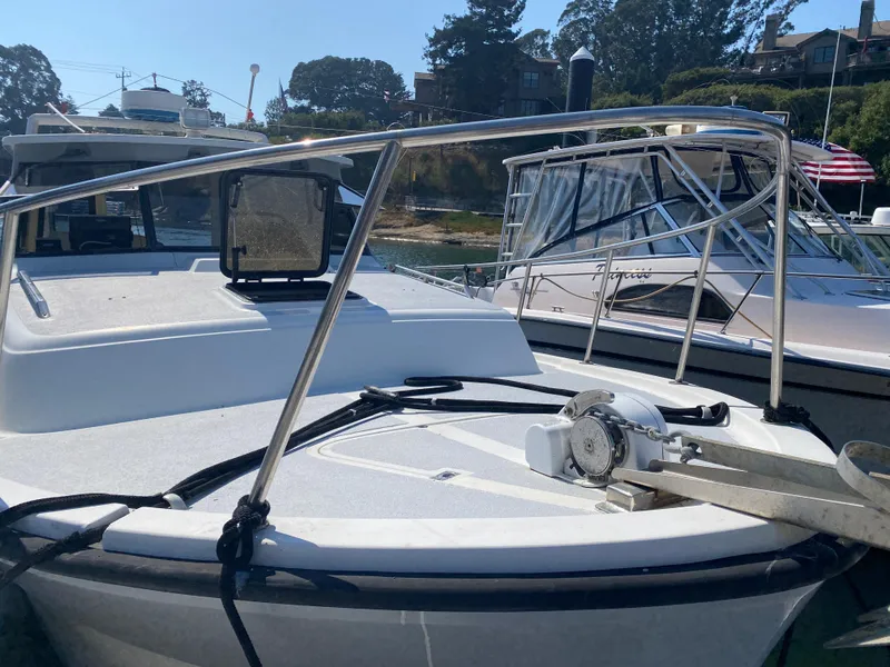 Slide: The Image of 1986 Luhrs Alura boat docked, featuring a sleek deck and stainless steel railings. - 4