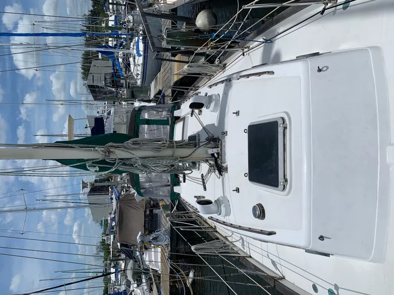 Slide: The Image of 1988 Pacific Seacraft Cutter sailboat docked at marina, clear sky, and surrounding boats. - 5