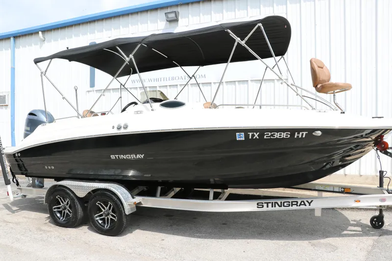 Slide: The Image of 2020 Stingray 212SC boat on trailer with black canopy. - 1