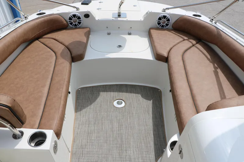Slide: The Image of 2020 Stingray 212SC boat interior with brown cushioned seating and carpeted floor. - 11