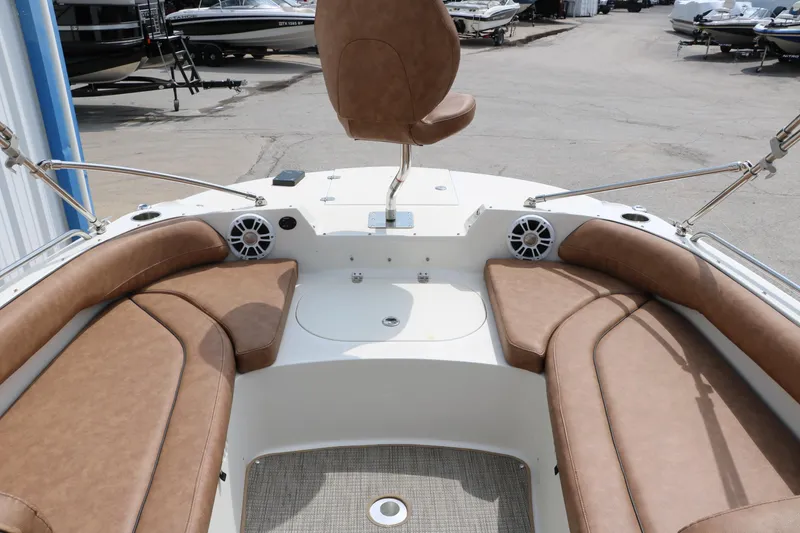 Slide: The Image of 2020 Stingray 212SC boat interior with brown seating and speakers. - 12