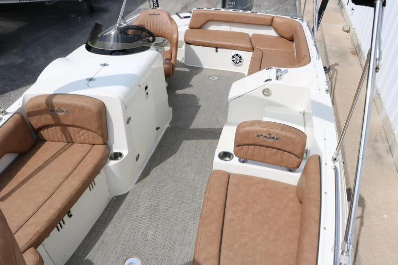 Slide: The Image of 2020 Stingray 212SC boat interior with brown cushioned seating and white console. - 13