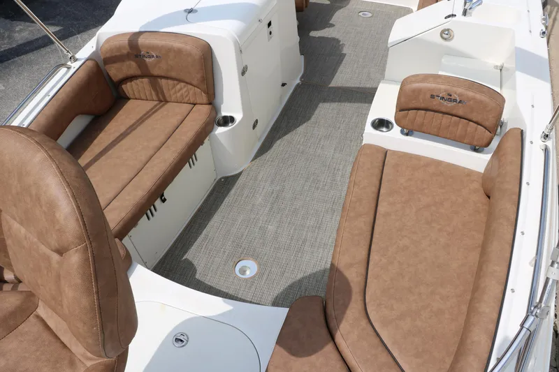Slide: The Image of 2020 Stingray 212SC boat interior with brown leather seating and gray carpet. - 14
