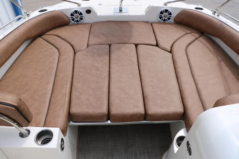 Slide: The Image of 2020 Stingray 212SC boat with spacious brown cushioned seating area. - 21