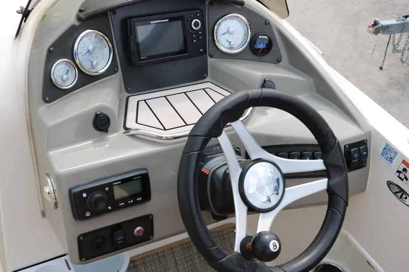 Slide: The Image of 2020 Stingray 212SC boat dashboard with steering wheel, gauges, and electronic controls. - 23