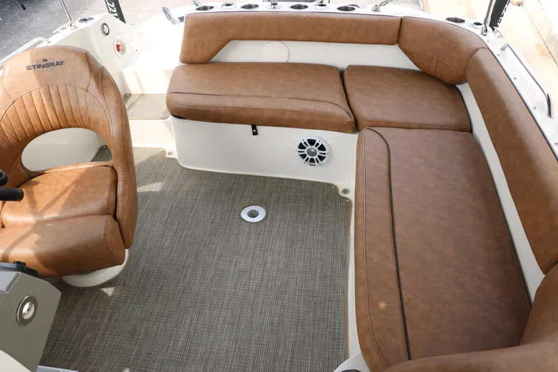 Slide: The Image of 2020 Stingray 212SC boat interior with brown leather seating and carpeted floor. - 28