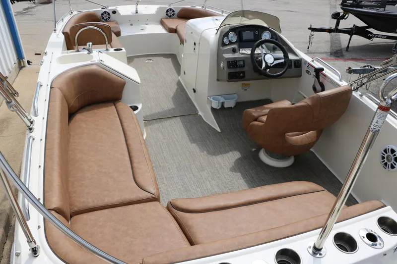 Slide: The Image of 2020 Stingray 212SC boat interior with tan seating and modern dashboard. - 3