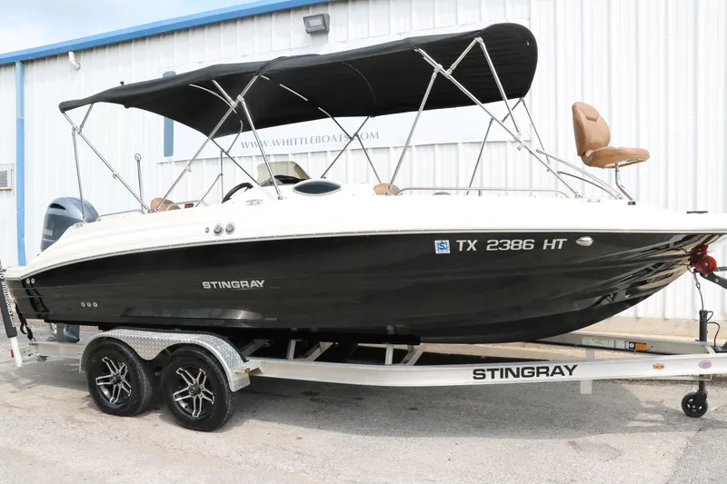 Slide: The Image of 2020 Stingray 212SC boat on trailer with black hull and canopy. - 32