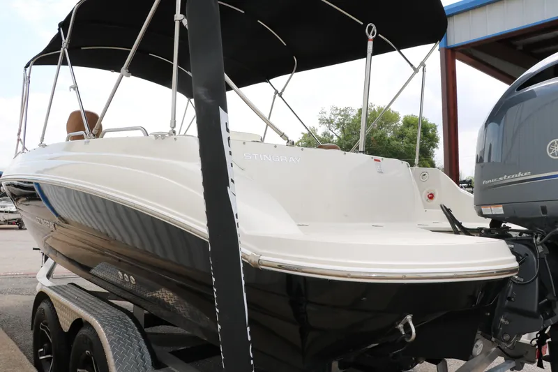 Slide: The Image of 2020 Stingray 212SC boat on trailer with black canopy. - 38
