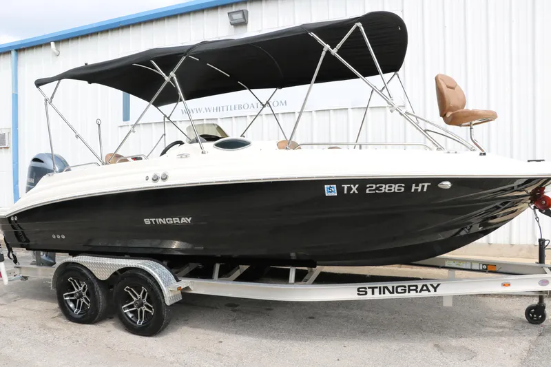 Slide: The Image of 2020 Stingray 212SC boat on trailer with black canopy. - 47