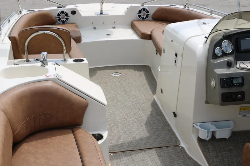 Slide: The Image of 2020 Stingray 212SC boat interior with brown leather seats and modern dashboard. - 5