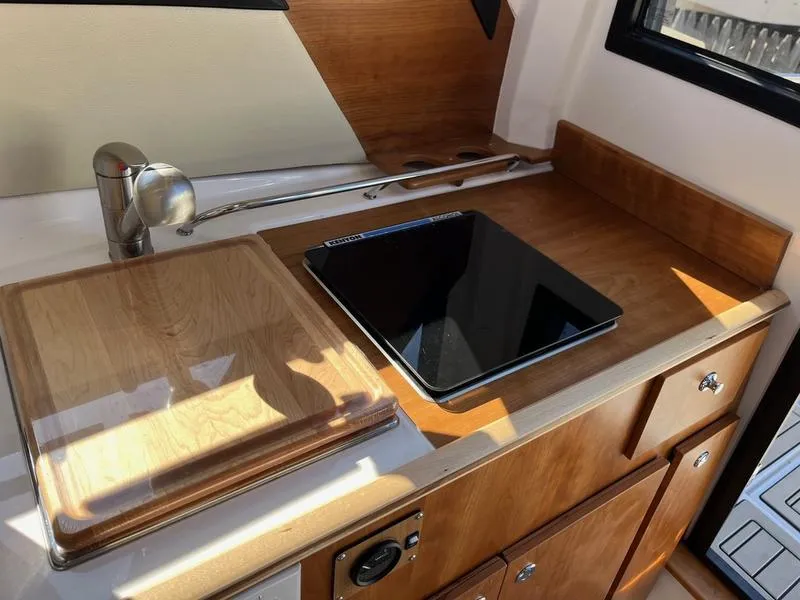 Slide: The Image of 2025 Cutwater C-248 C Coupe boat kitchen with wooden cabinetry and modern appliances. - 10