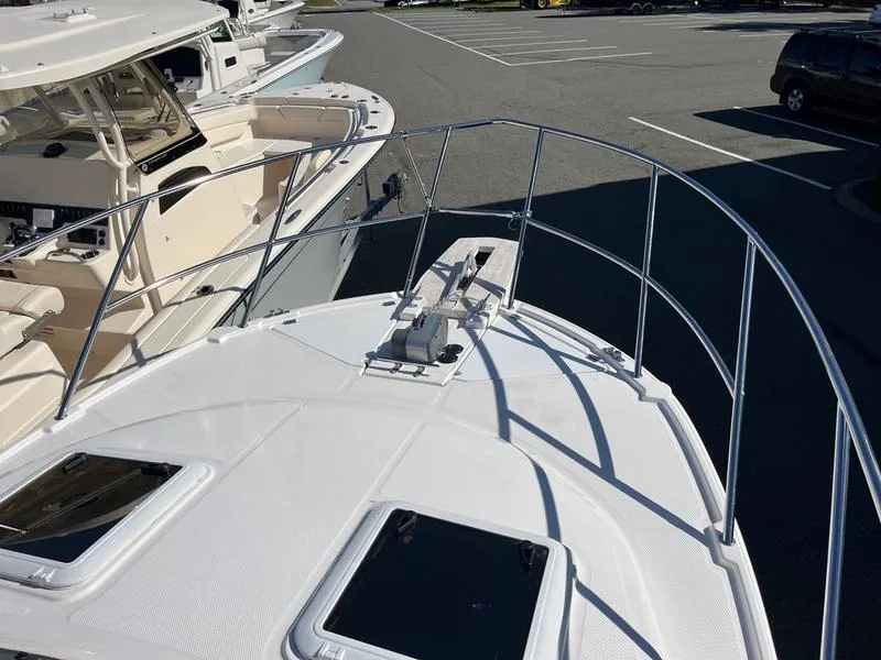 Slide: The Image of 2025 Cutwater C-248 C Coupe boat deck with railing and hatches in a marina. - 17